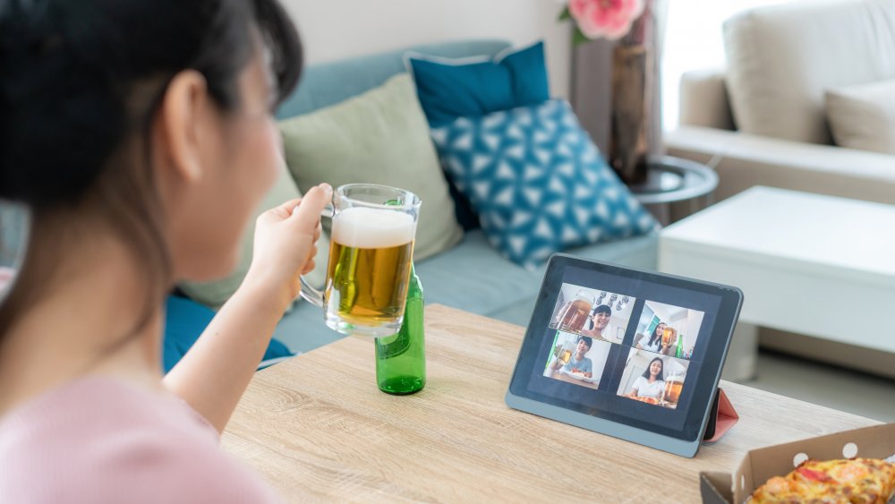 Woman drinks beer on a video call