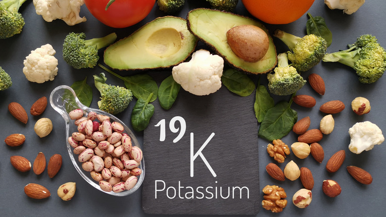 Vegetables, fruit and foods containing potassium over gray stone background, top view. 