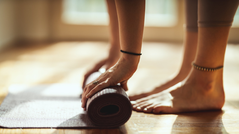 Person rolling up yoga mat