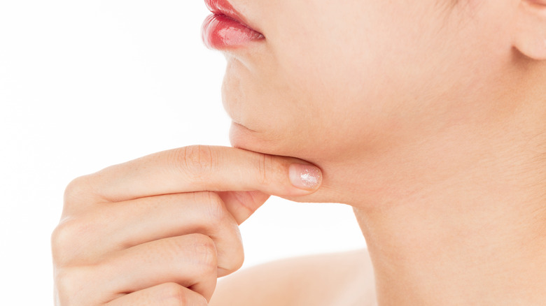 Woman pinching the fat on her chin