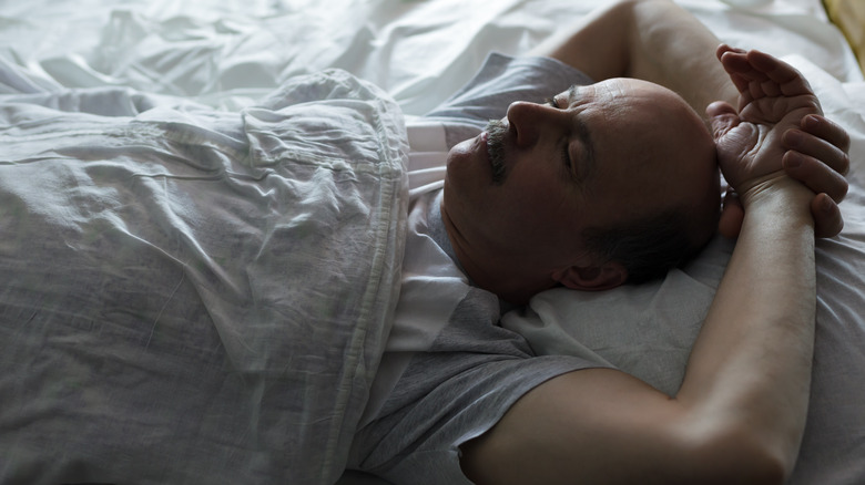 Older man sleeping on back