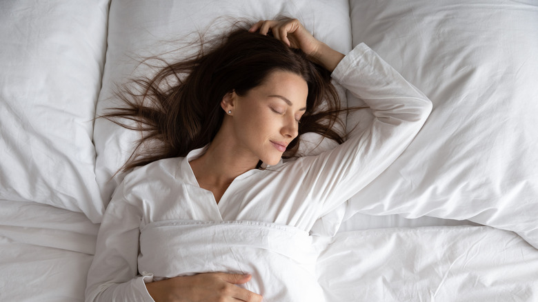 A woman sleeps peacefully on her back