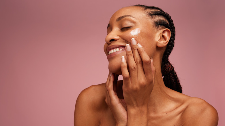 Black woman applying eye cream