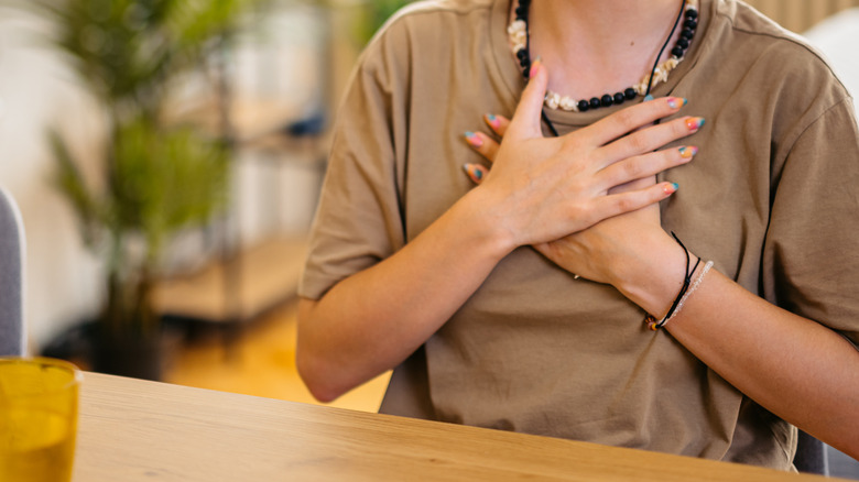 young woman clutching chest