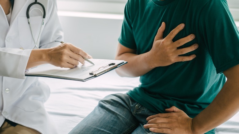 doctor assessing patient with hand on chest