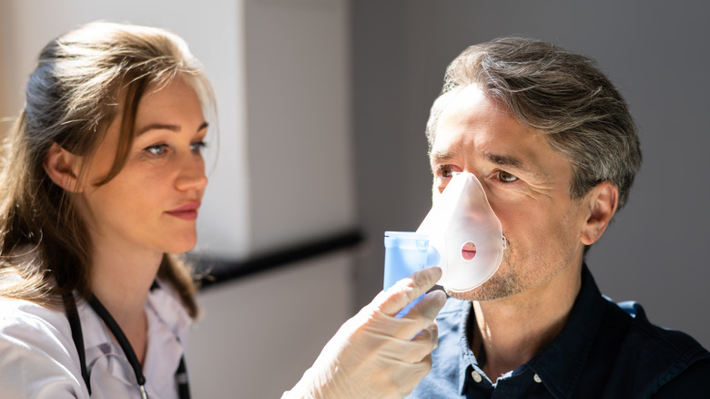 doctor giving man breathing treatment
