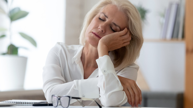 tired woman resting head in hand
