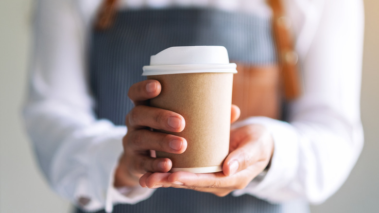 A waiter holds a cup of coffee