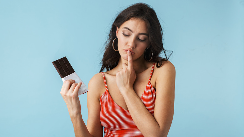 Woman holding dark chocolate bar