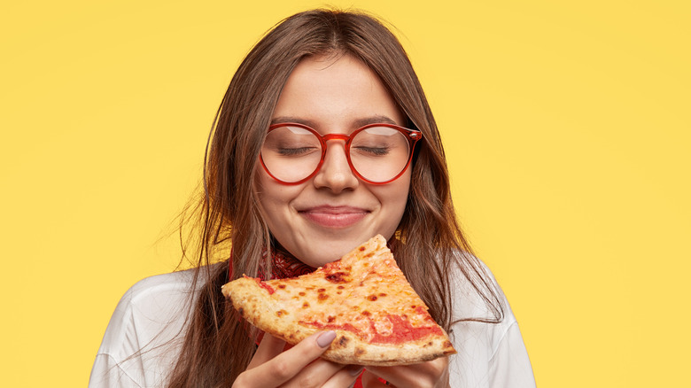 Girl with glasses eating pizza