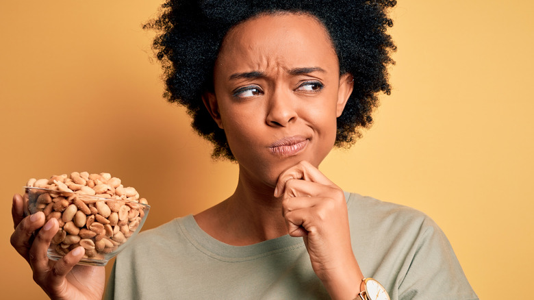 Woman holding a bowl of peanuts in her hands