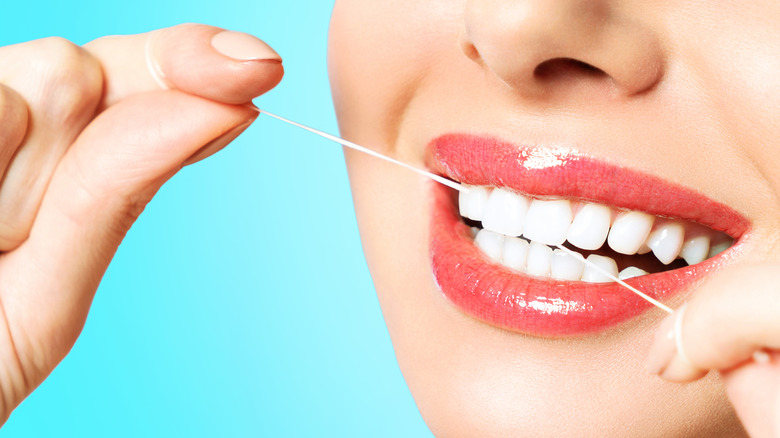 Close up of woman flossing her teeth