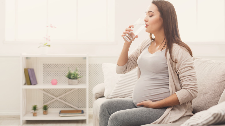 pregnant woman drinking glass of water
