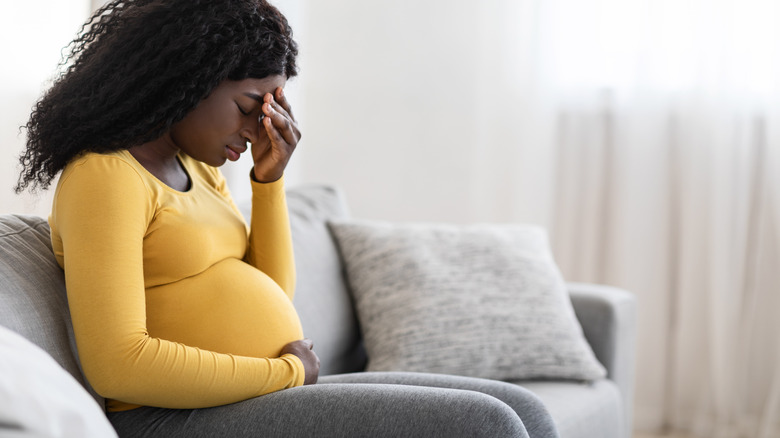 unwell pregnant woman on the couch