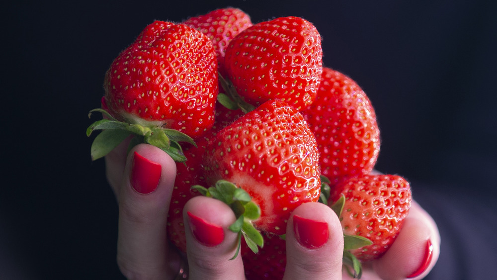 person holding strawberries