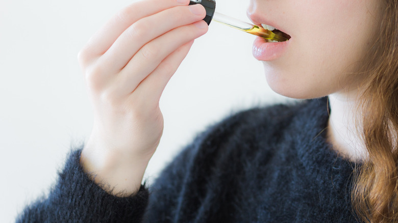 woman with cbd dropper in her mouth