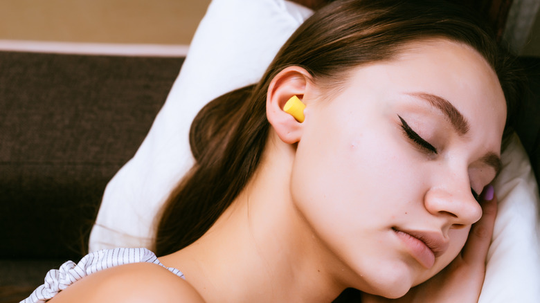 woman sleeping with earplugs