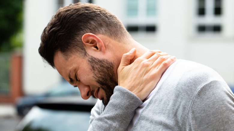 man holding sore neck