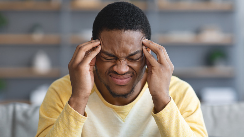 man holding head for headache pain