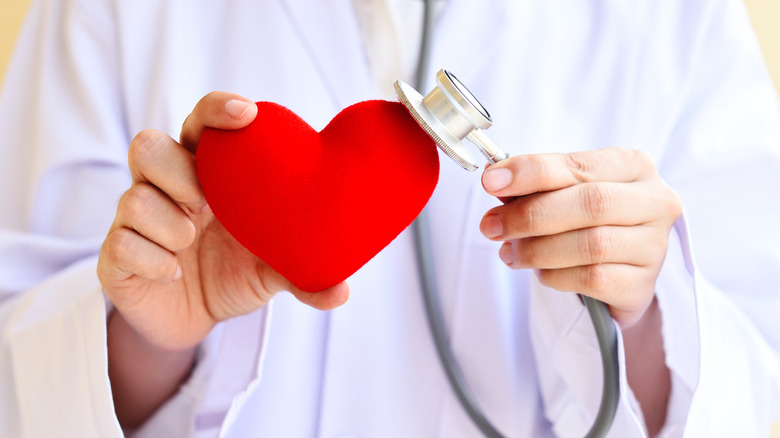 doctor with stethoscope on a plastic heart
