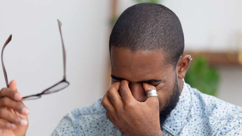 A young man rubbing his eyes