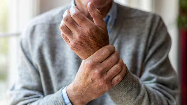 Close up of hands, one rubbing wrist