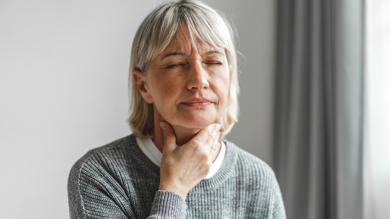 A woman rubbing her throat