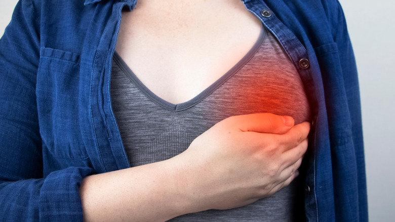 woman cupping her breast, red with pain indication