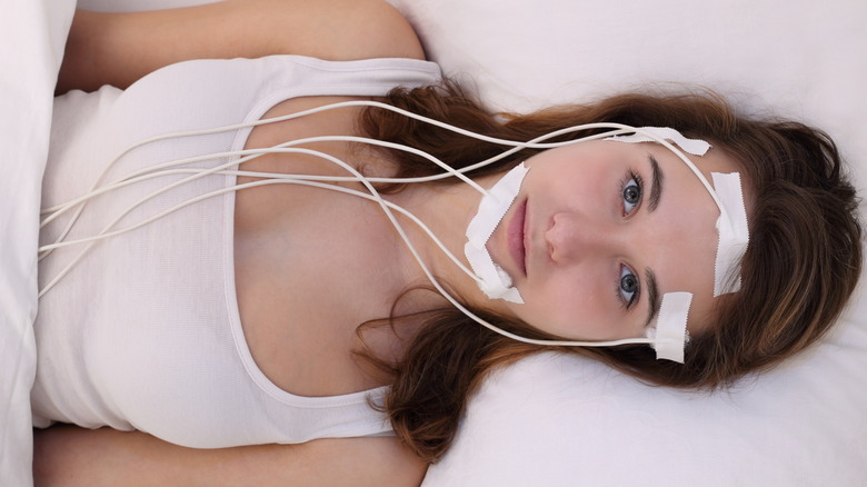 Woman on bed with electrodes