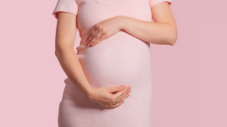 Pregnant woman cupping her belly