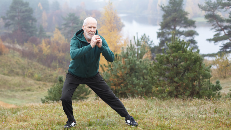 An older gentleman performing a side lunge