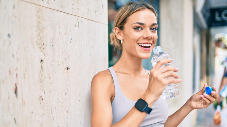 Blonde woman drinking bottled water