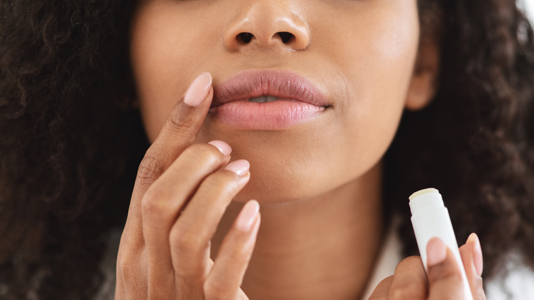 Close-up of woman applying lip balm