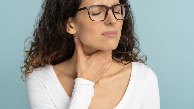 Woman grabbing her sore throat