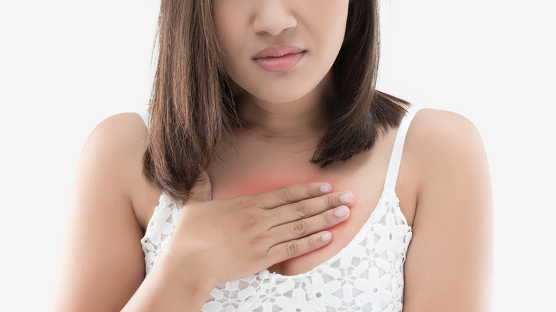 Woman holding her chest in pain