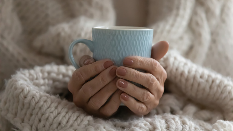 hands holding a cup of tea