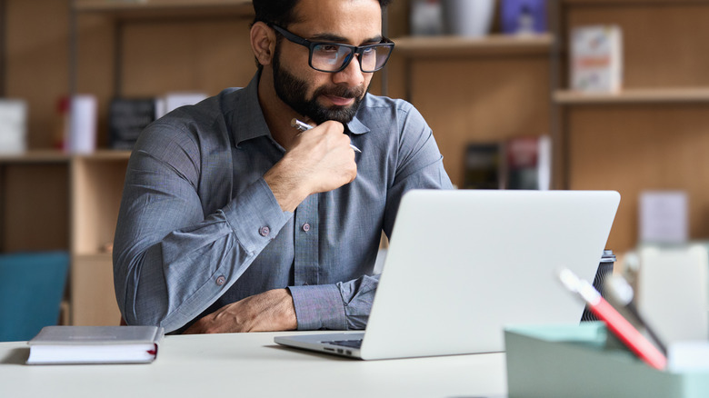 Man with glasses using laptop