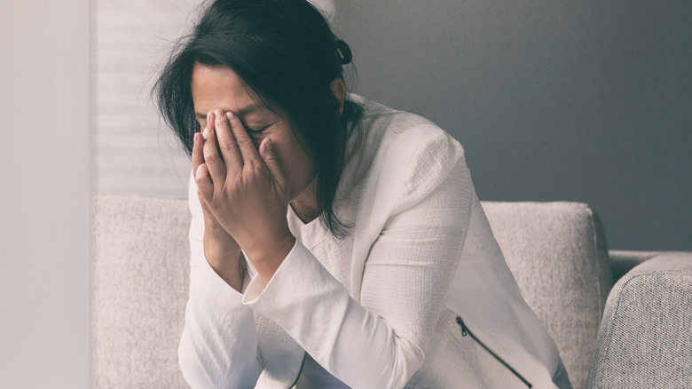 Sick and frustrated woman holding her face