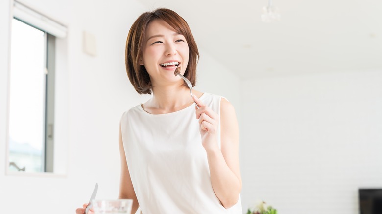 Asian woman eating salad