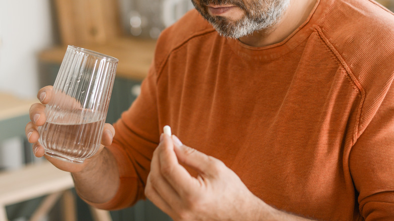 Man holding white pill