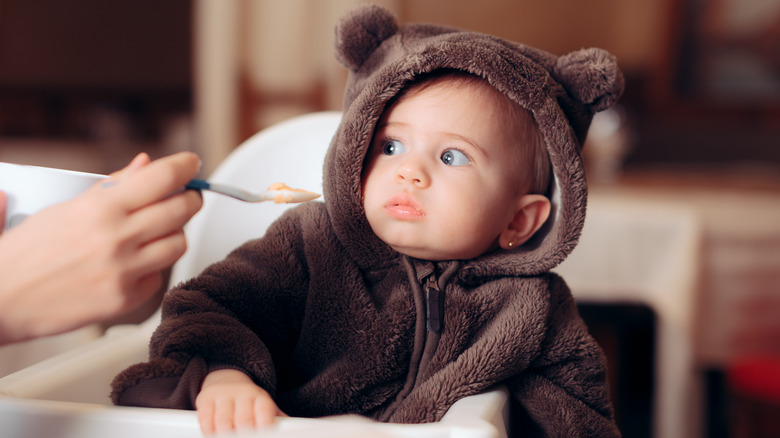 Funny Baby Sitting in Highchair Refusing to Eat