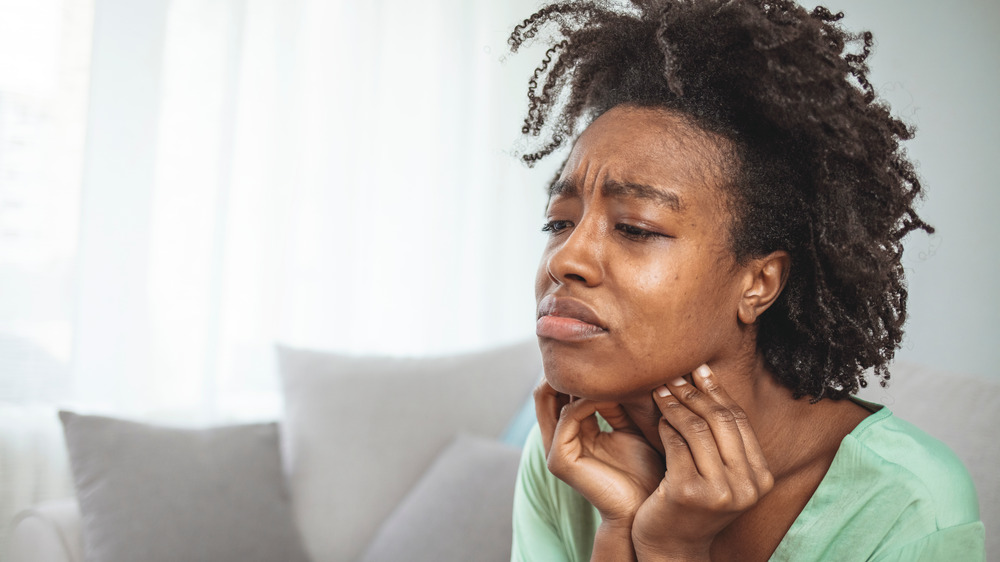 Woman holding throat in pain