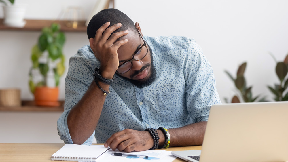 Man tired at work with laptop