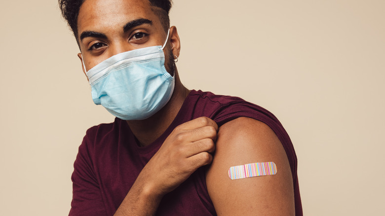 Man wearing mask and Bandaid on arm