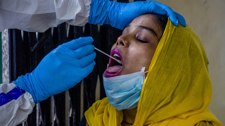 Woman getting COVID-19 swab test in India