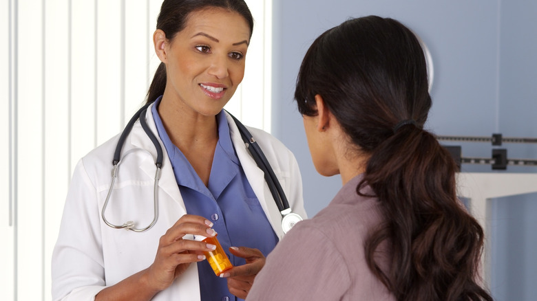 OBGYN handing prescription to patient