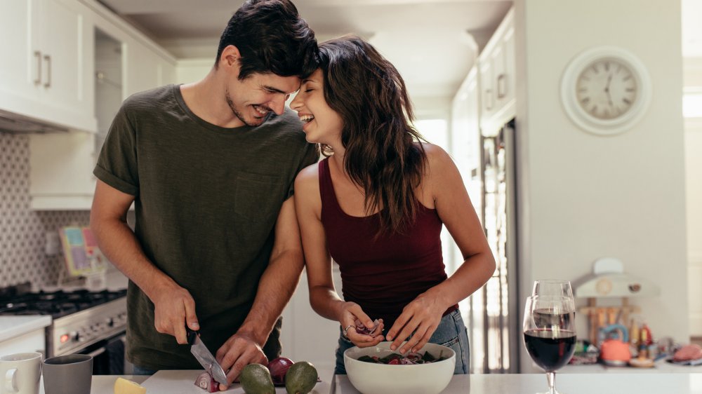 man and woman preparing food in the kitchen