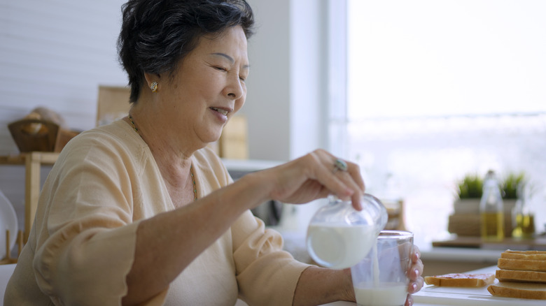 Woman pouring glass of milk