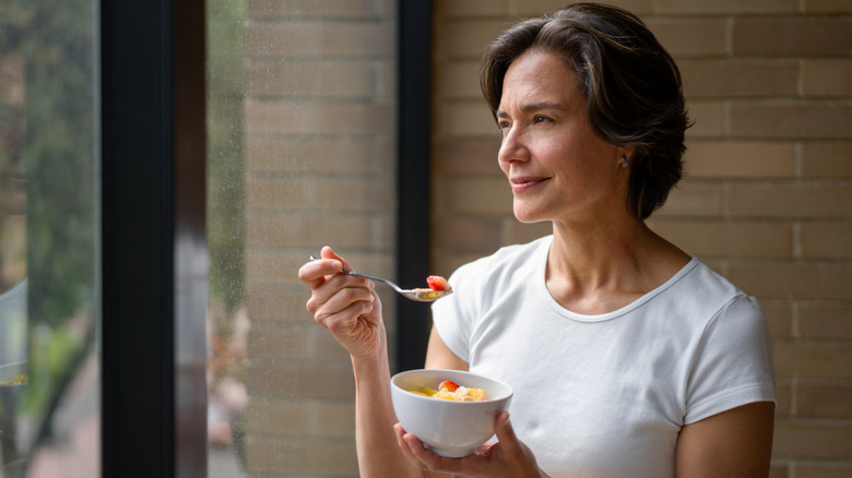 woman eating a bowl of fruit