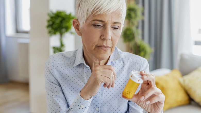 woman looking at her bottle of medication